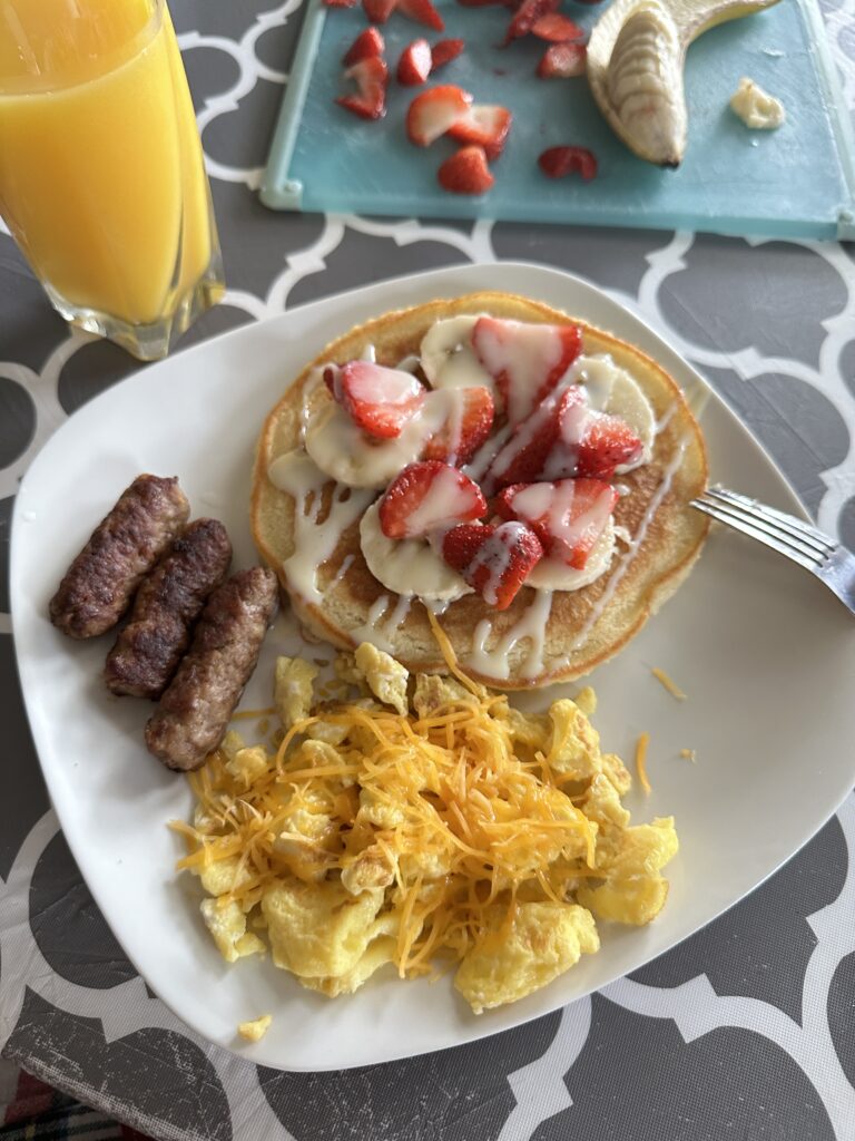 Pancakes with Strawberries and Bananas, Sausage, and Eggs with Cheese